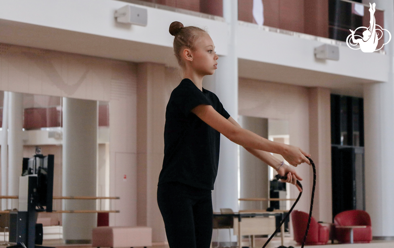 Гимнастка работает над техникой со скакалкой