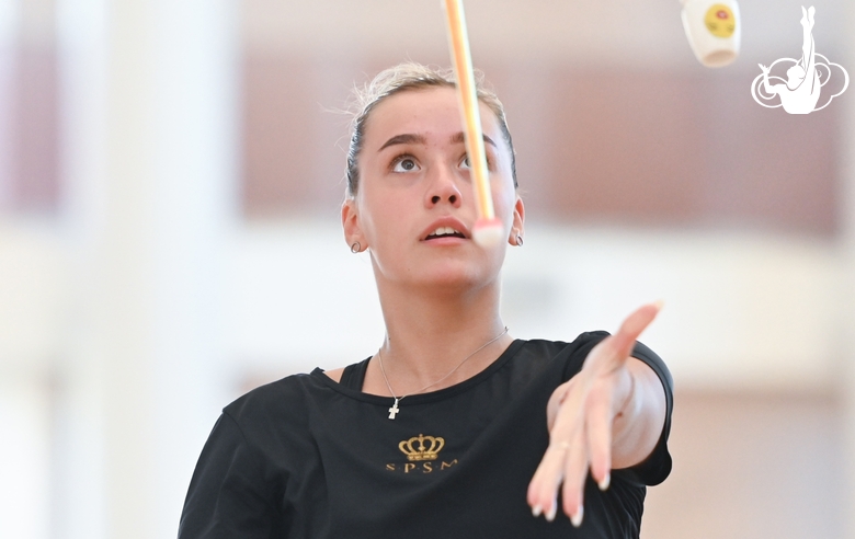 Мария Победушкина выполняет упражнение с булавами