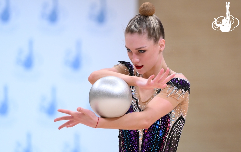 Гимнастка во время упражнения с мячом