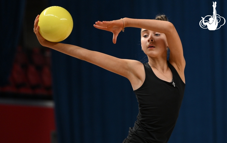 Гимнастка во время упражнения с мячом на опробовании ковра в Академии единоборств