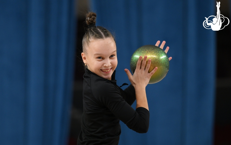 Гимнастка во время упражнения с мячом на опробовании ковра в Академии единоборств