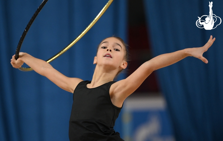 Гимнастка во время упражнения с обручем на опробовании ковра в Академии единоборств