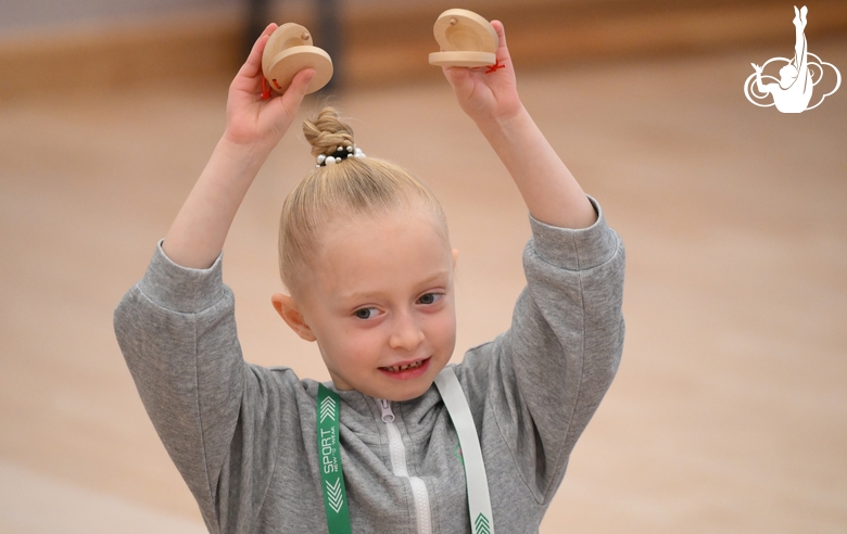 Юная гимнастка во время занятия ритмикой