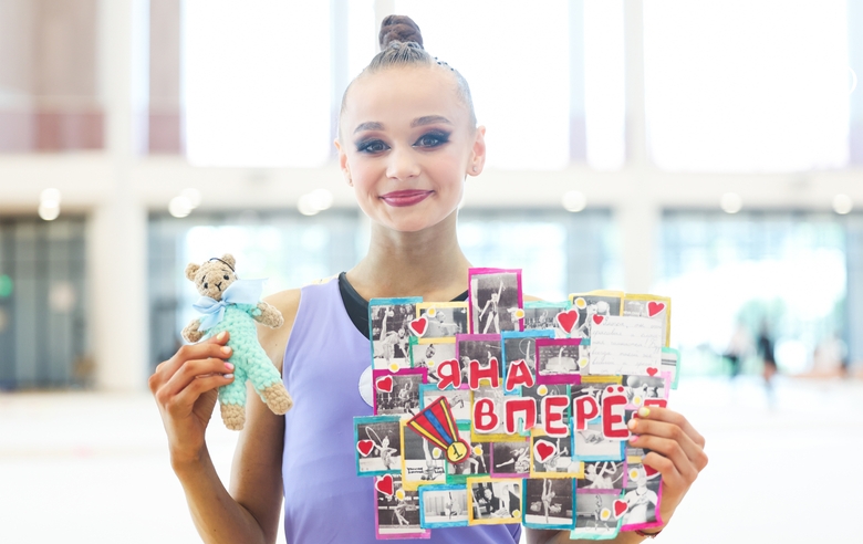 Яна Заикина с плакатом и игрушкой от болельщиков