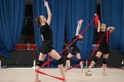 Гимнастки во время упражнения с мячами и лентами на опробовании ковра в Академии единоборств