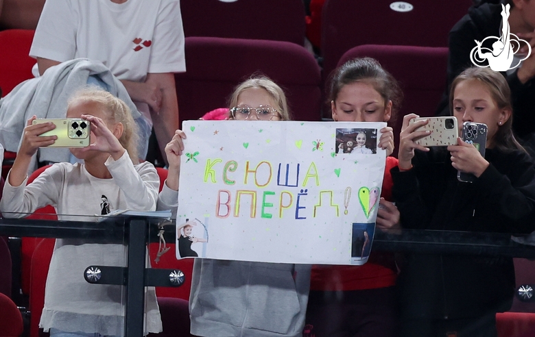 Юные гимнастки поддерживают Ксению Савинову на соревнованиях