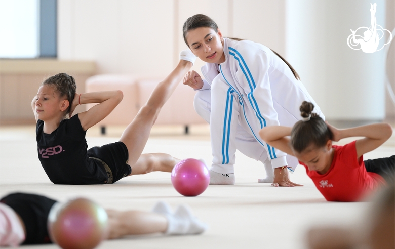 Тренер Екатерина Лоц с гимнасткой во время занятия на учебно-тренировочных сборах в Академии