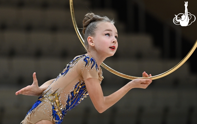 Гимнастка в упражнении с обручем во время выступления