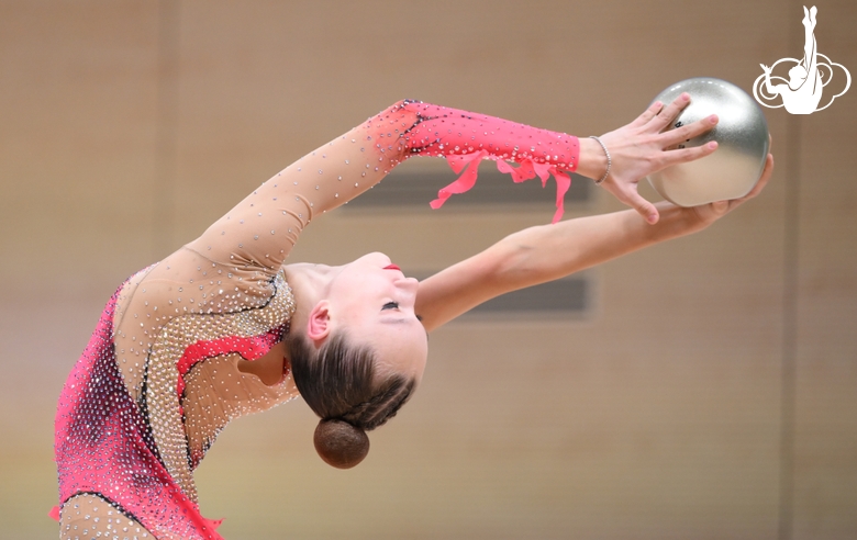Гимнастка во время упражнения с мячом