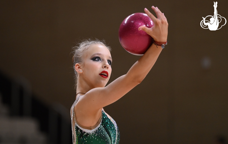 Гимнастка во время упражнения с мячом